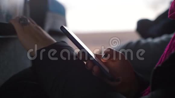 一个黑指甲的女孩在火车上使用智能手机视频的预览图