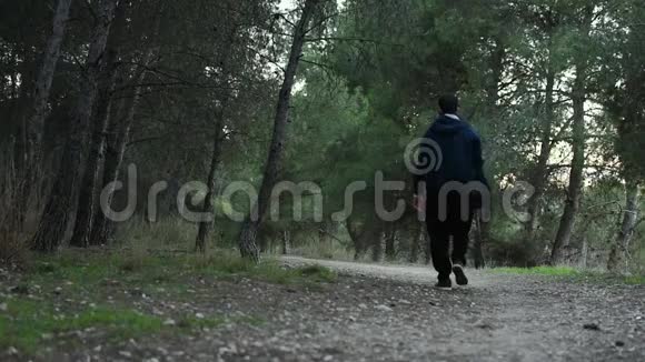 年轻人背着背包在森林里散步视频的预览图