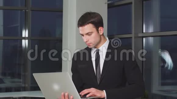 自信的现代商人手里拿着笔记本电脑的画像视频的预览图