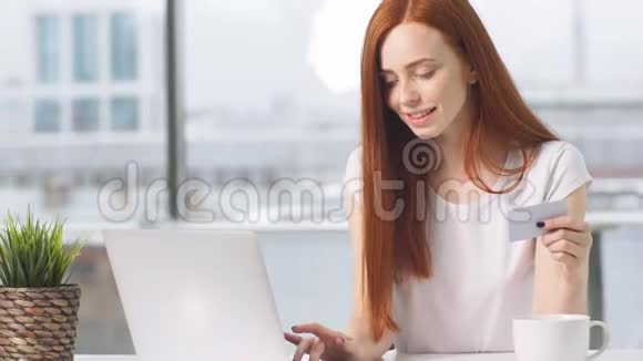 年轻女孩在网上购物用信用卡支付视频的预览图