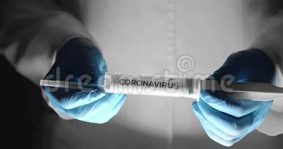 戴手套的医生拿着注射器上面写着冠状病毒视频的预览图