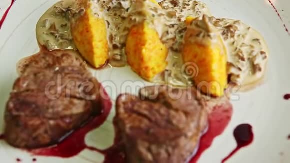 用红酱和土豆装饰在盘子上旋转的肉片视频的预览图