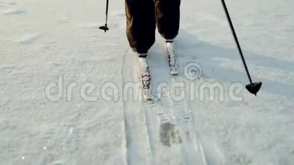 一个女人滑雪很经典冬季滑雪雪地特写镜头上有滑雪板的腿视频的预览图