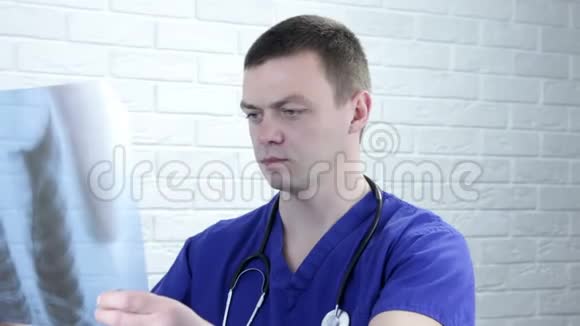 穿着蓝色外套的男医生在办公室里看着肺的x射线照片保健伦琴视频的预览图