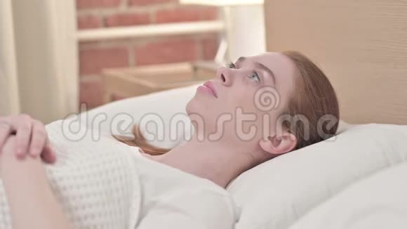 担心红头发的年轻女人想睡在床上视频的预览图