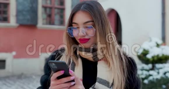 戴眼镜的女人看着市中心的相机姿势美丽的头发迷人的微笑女孩双手近距离射击视频的预览图
