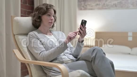 沙发智能手机上的悲伤女人视频的预览图