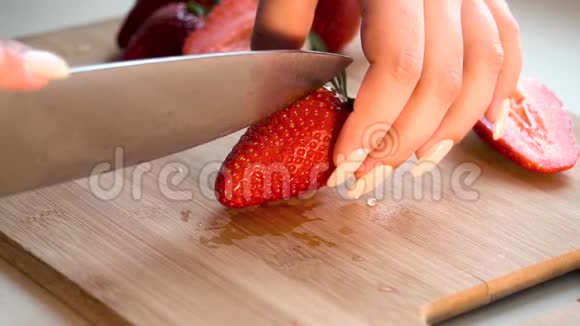 女孩用刀切出多汁的成熟新鲜草莓视频中含有噪音视频的预览图