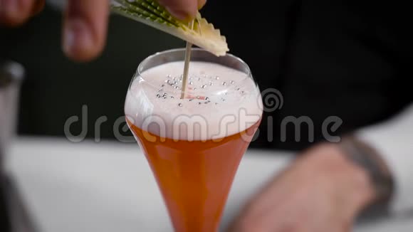 鸡尾酒已经准备好了酒保给顾客带了一杯设计精美的饮料酒精有助于娱乐视频的预览图