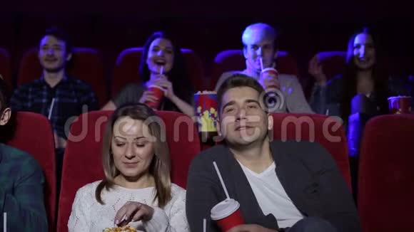 一对夫妇坐在一起看电影看喜剧或浪漫电影视频的预览图