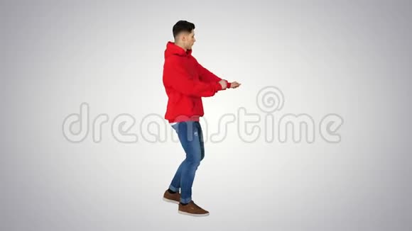 英俊的年轻人穿着红色帽衫在渐变背景下跳舞视频的预览图