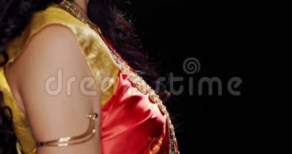 年轻的印度妇女穿着红色和金色连衣裙侧写拍摄4k视频的预览图