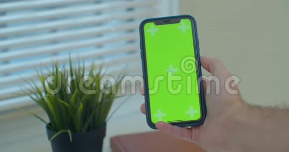 人使用垂直智能手机与绿色屏幕男人用手机手的特写镜头铬钥匙快关门视频的预览图