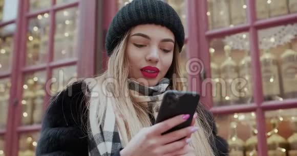 年轻女子戴着头巾在市中心散步使用智能手机交流网上购物社交视频的预览图