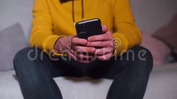 一个戴着面具的男人手中的智能手机的特写视频的预览图