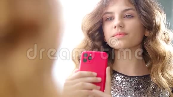 使用智能手机的美丽女孩的视频她站在镜头前视频的预览图