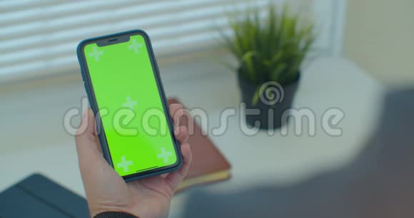 人使用垂直智能手机与绿色屏幕男人用手机手的特写镜头铬钥匙快关门视频的预览图