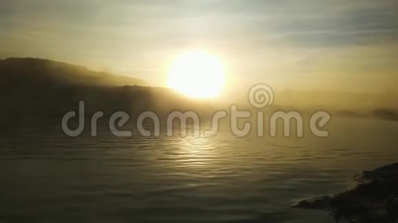 太阳升起时热池蒸汽上升到水面以上放松视频的预览图