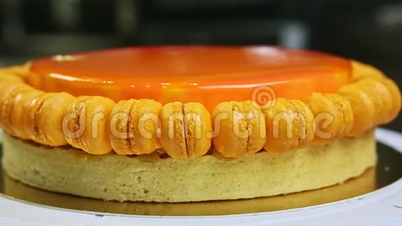 带有小马卡龙的橙色釉面芝士蛋糕视频的预览图