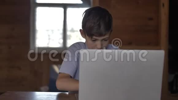男孩已经在笔记本电脑上工作正在家里等待结果视频的预览图