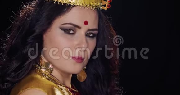 戴着珠宝的害羞印度女人在黑色背景上摆姿势4k视频的预览图