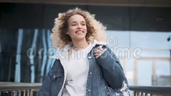 无忧无虑的快乐和乐趣一个年轻迷人的女孩走在街上笑容满面视频的预览图