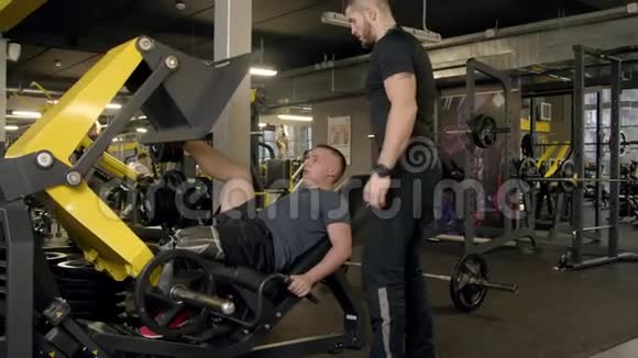 健身房用压腿机做假肢的年轻人视频的预览图