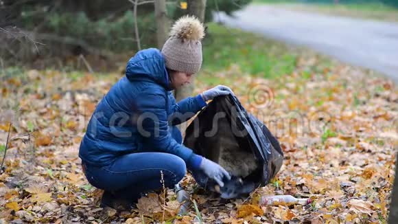 女孩打扫森林里的土地用袋子收集垃圾视频的预览图