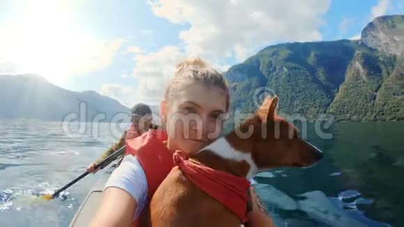 带着可爱的狗在皮艇上快乐的女旅行者视频的预览图