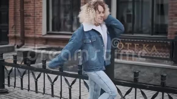 有趣的女孩在街上跳舞很有趣快乐卷曲金发女郎的肖像视频的预览图