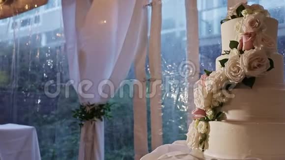 在婚礼蛋糕上用大玫瑰装饰的慢全景视频的预览图