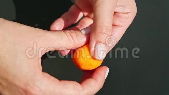 从一小块橘红色的杏仁糖上可以看到特写女性的双手视频的预览图