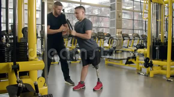 有教练在健身房工作的残疾青年视频的预览图