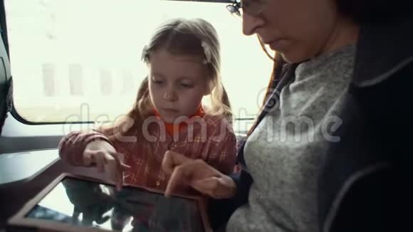 妈妈和女儿在火车上使用触摸板视频的预览图