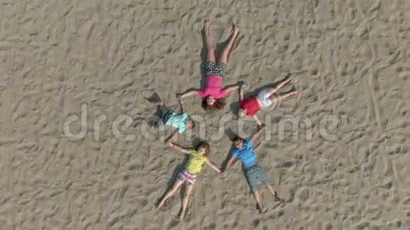 孩子们像星星一样躺在沙滩上视频的预览图