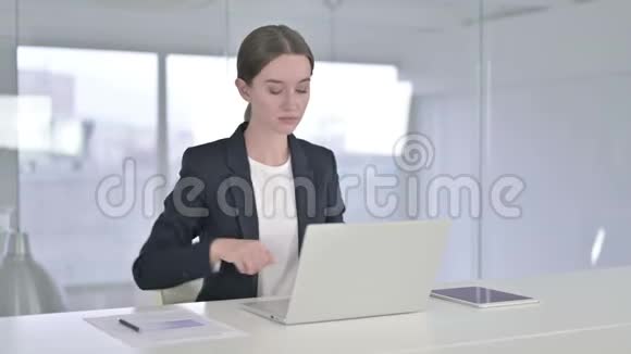 疲惫的年轻女商人在办公室里背疼视频的预览图