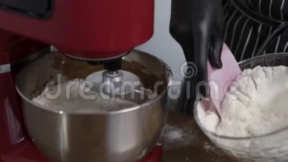 厨师用红色的厨房搅拌机做面团厨师添加面粉以获得正确的稠度视频的预览图