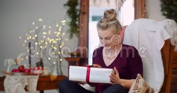 坐在家里的椅子上拿礼物的女人视频的预览图