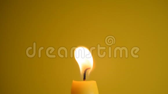 黄色背景上的蜡烛火焰特写视频的预览图