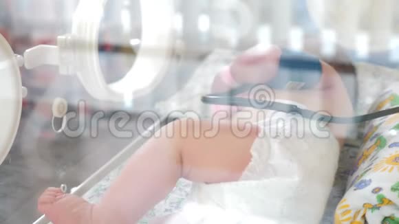 在产科医院的婴儿从玻璃上射出的脚印新生的生命拯救强化医院视频的预览图