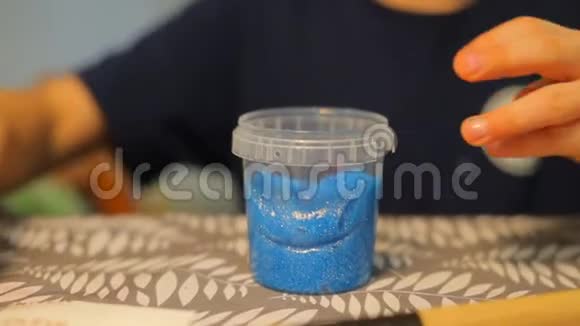 桌子上有蓝色油漆的小罐子的特写视频的预览图