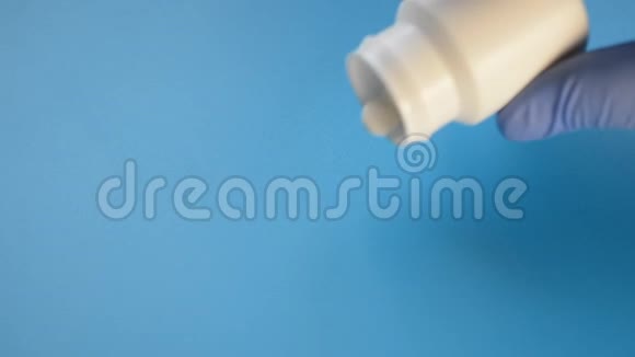 白色瓶子带有蓝色背景的彩色药片治疗冠状病毒的概念视频的预览图