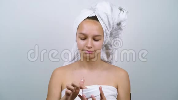 穿着浴巾涂面霜的青少年视频的预览图