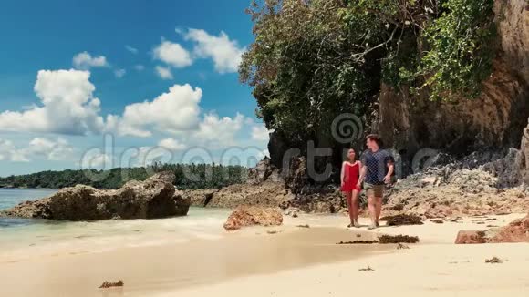 快乐的跨种族夫妇在夏天的沙滩上散步视频的预览图
