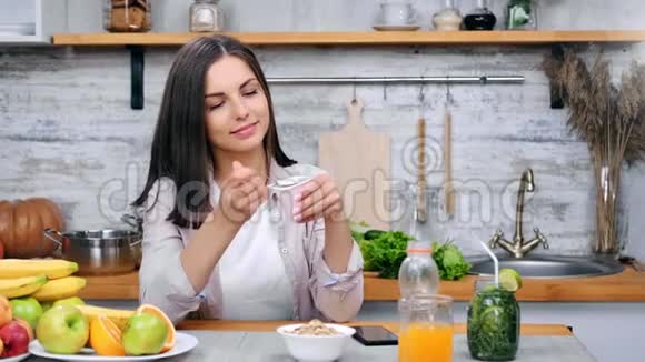 美丽微笑的肖像女人在美容美食中用勺子吃开胃的酸奶视频的预览图