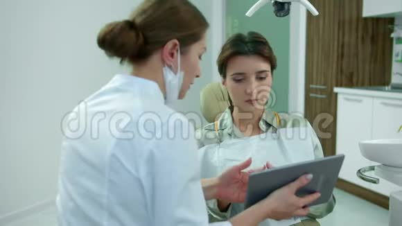 牙医会和病人说话并在药片上给她看东西视频的预览图