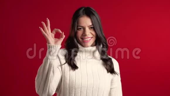 年轻的拉丁女人穿着完美的毛衣在红色上签名视频的预览图