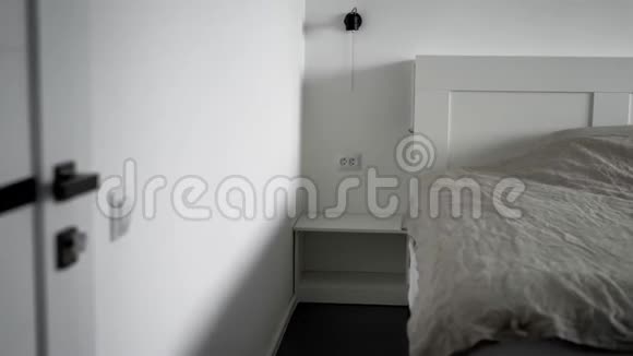 现代卧室的内部一间明亮的房间有白色的墙壁一张宽床有毯子和枕头视频的预览图
