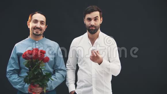 两个男人并排站着玫瑰和戒指微笑着看上去很开心不典型的方向视频的预览图