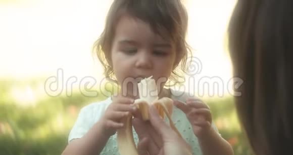 在户外吃香蕉的小女孩视频的预览图
